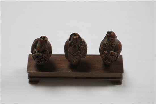 A set of six Chinese peach stones carved as immortals and a monkey, rosewood stands, each approx. height 4cm